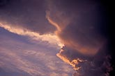 Abstract: sunset edges a billowing storm with pink