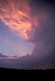 An immense heavenly pink storm cloud billows up