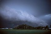 A frightening, powerful storm gust front descends upon a farmhouse