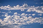 Scraps of Altocumulus cloud scatter over a blue sky