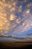 Golden light enchants jewel-like clouds in a cloud bedecked twilight 