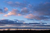 Long, low strips of cloud in a meditative twilight cloudscape
