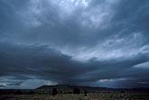A low dark cloud dips down toward the land, dropping showers 