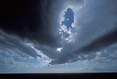 Dark cloud bands converge in a changing sky