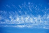 Feathery clouds in a bright blue sky abstract