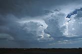 A dominant storm controls nearby clouds, flattening weaker Cumulus