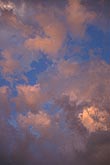 Abstract with harmonious salmon colored clouds in a bright blue sky