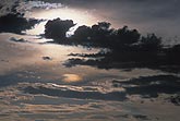 A mysterious, haunting twilight glow silhouettes dark clouds