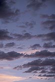 Delicate gray clouds against pale pink and blue in a twilight sky