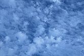 Small tufted turrets of cloud in a textured sky abstract