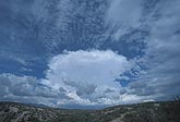 A puffy storm cloud in a speckled sky 