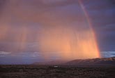 A brilliant sunset sheen enchants rain beneath a rainbow 