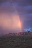 Sunlight striking billions of raindrops brightens inside of rainbow