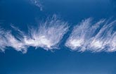 Tufts of wispy cloud in a deep blue sky