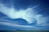 Sweeping clouds arc over a rural landscape