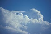 Pileus clouds top a towering convection in a field of Cumulus clouds