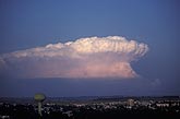 The perfect anvil of a thunderhead looms like a mushroom cloud 