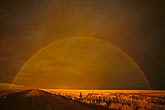 A dark and eerie full rainbow at sunset