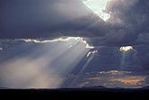 A sunbeam, or shaft of light, burst from dark clouds