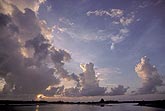 Towering Cumulus clouds at sunset over water