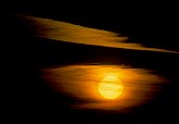 The sun disk glows orange in an eerie sunset