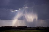 Silvery crepuscular rays paint rain with a heavenly glow