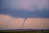 Snaky tornado in softly colored sunset sky
