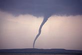 Close view of a slender, curved tornado at twilight