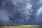 A turbulent wall cloud hangs low from a storm