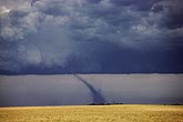An elongated tornado, its funnel stretched by outflow winds