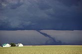 Lonely farm buildings with a tornado in the background