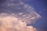 Soft cloud heaves up under a striated anvil cloud flange