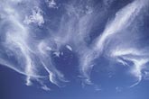 Fanciful clouds dance with joy in a blue sky.