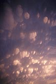 Mammatus cloud pouches glow with mysterious sunset light