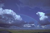 Sidelighting on building clouds bridged by rainbow