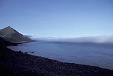 A distant bank of advection fog or sea fog off a lonely shoreline