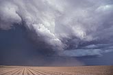 A shelf cloud, with winds carrying thin blowing dust before the rain